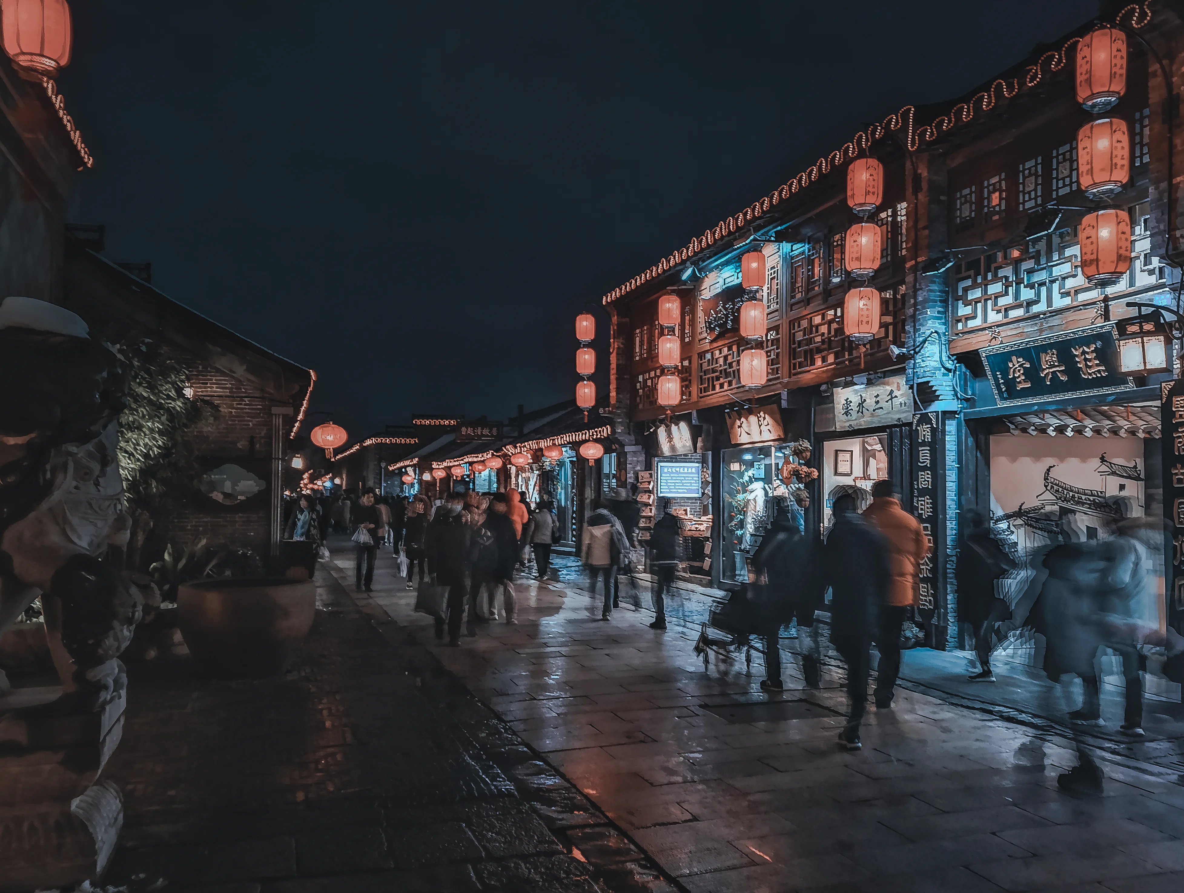 Visitors walking beneath lanterns along Dongguan Street at night