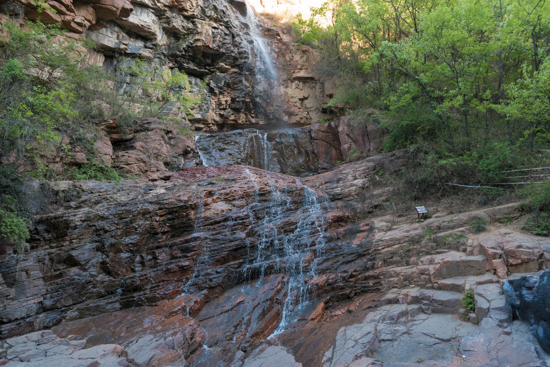 Rock walls, trees and a narrow waterfall in Fuxi Mountain