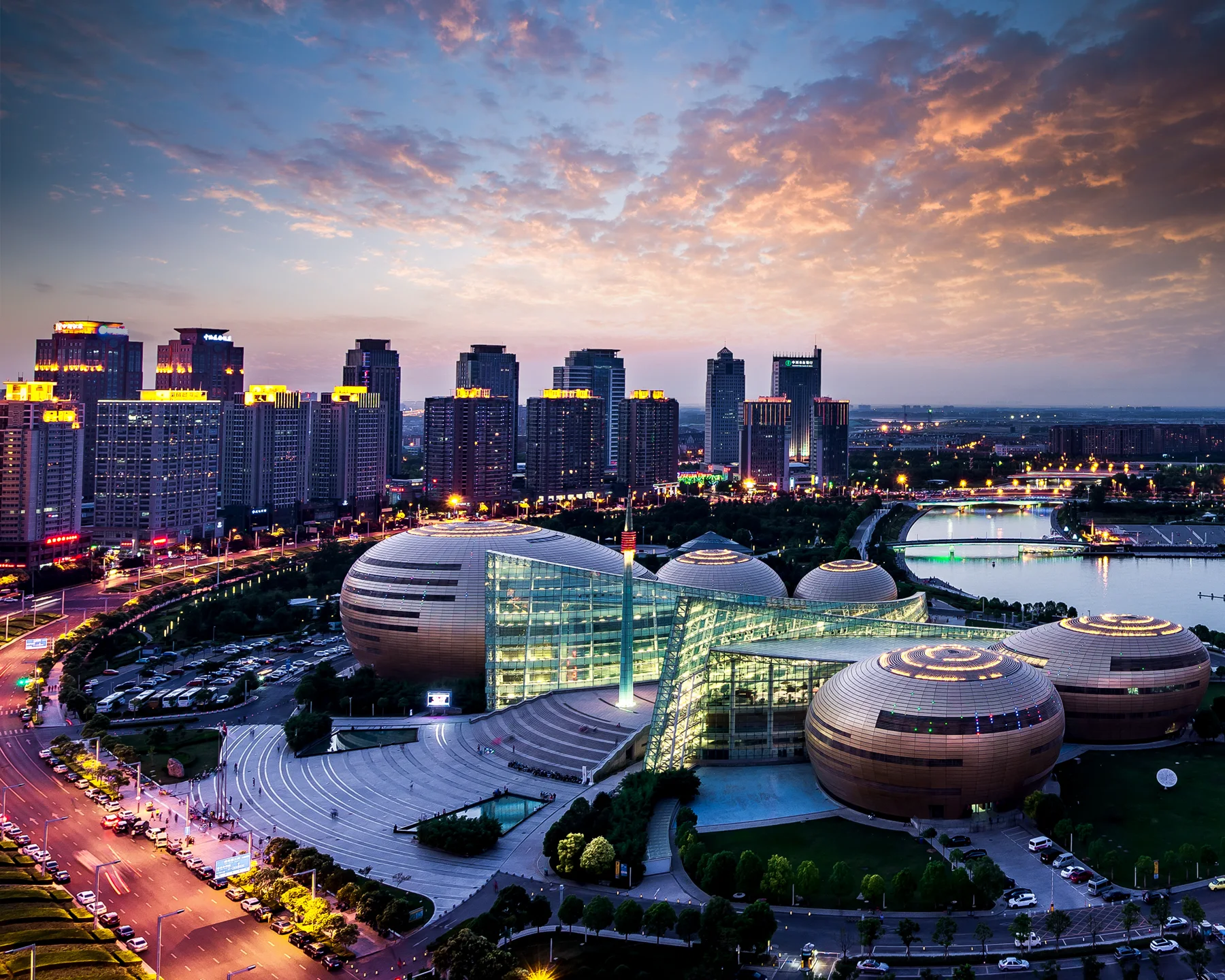 Henan Art Center and the Zhengdong skyline surrounding Ruyi Lake at dusk