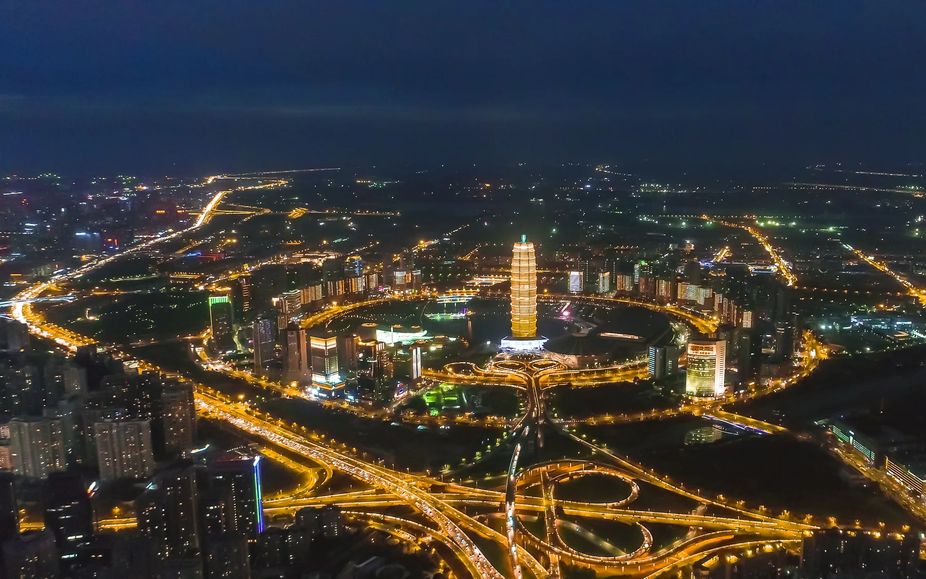 Zhengdong New District reflected across the waterfront after dark
