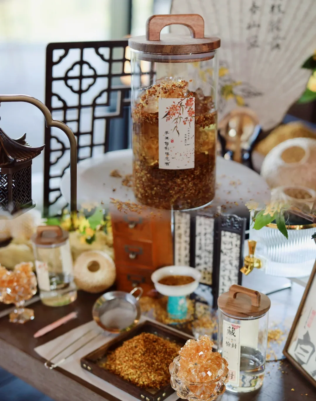 A real autumn display with osmanthus flowers, dried blossoms and glass vessels used to present osmanthus infusions