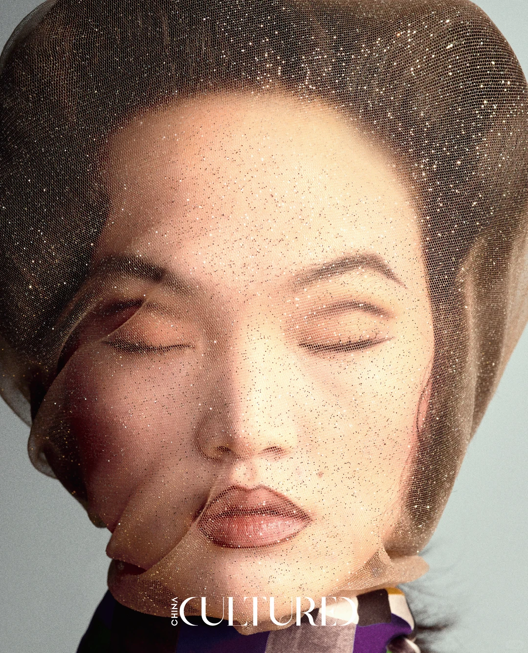 Two faces overlapped beneath a glittered mesh layer in a fashion editorial close-up