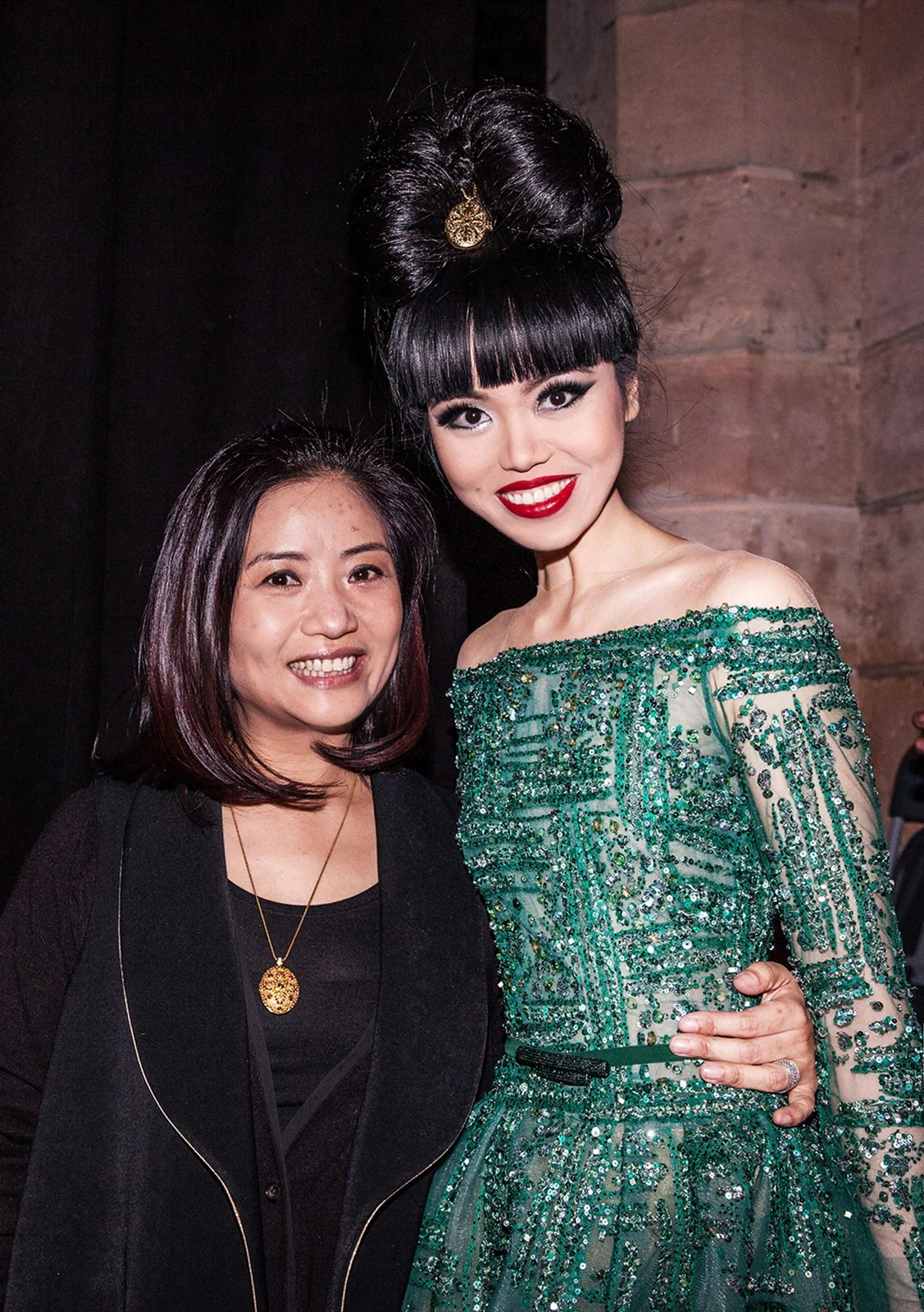 Chinese designer Guo Pei beside a model in a beaded runway garment, joining authorship, construction and global fashion circulation