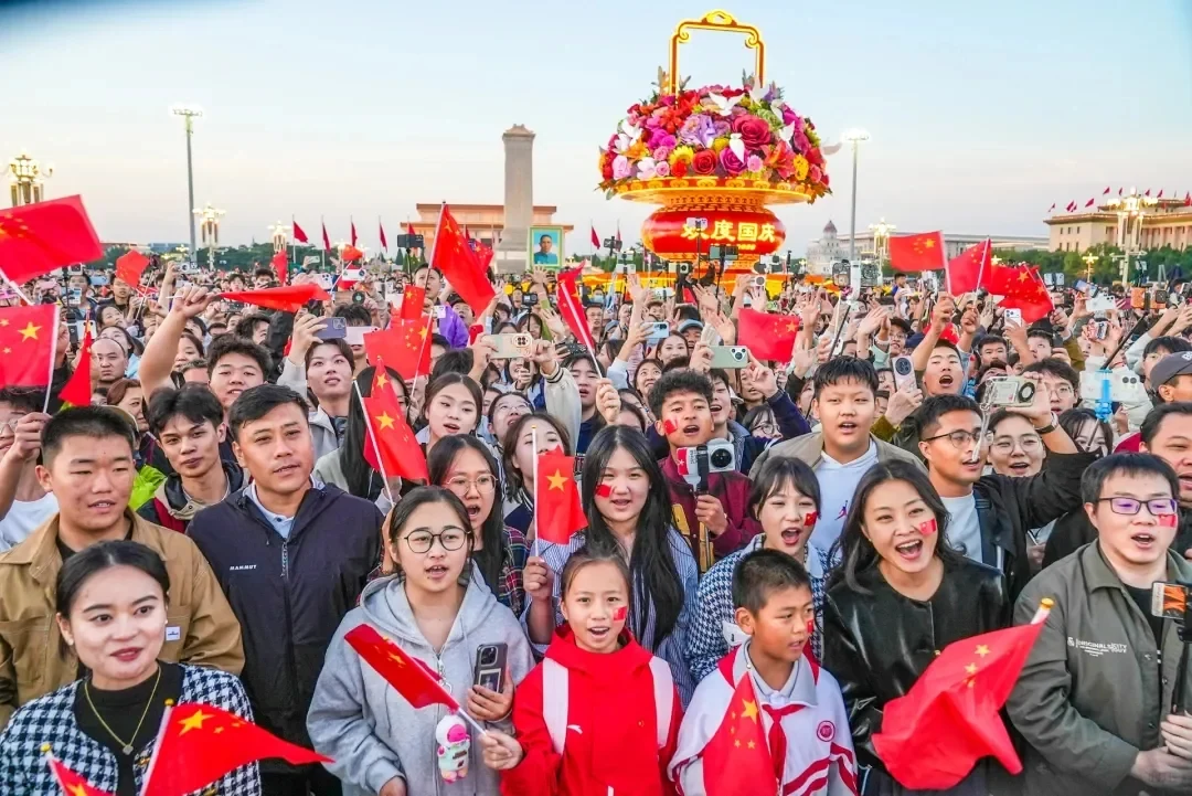 Families, children and young visitors wave Chinese flags at Tiananmen Square on the morning of China National Day