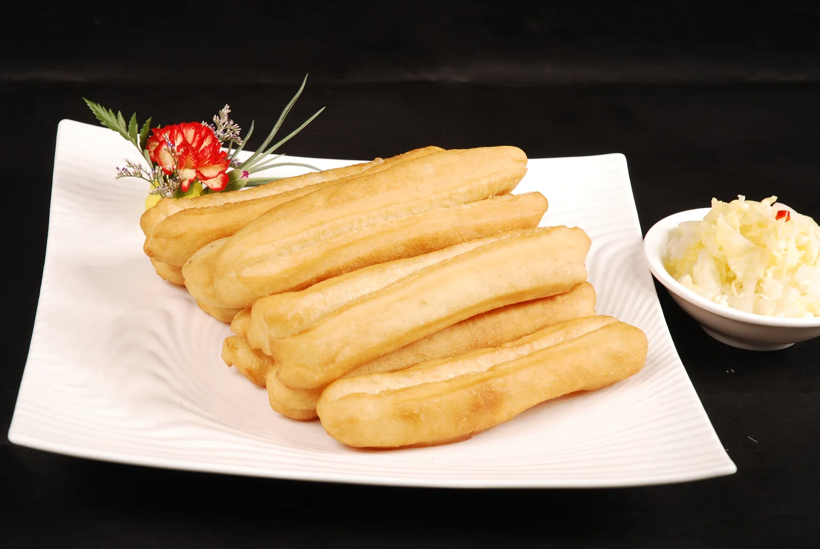 Chinese breakfast food youtiao on a plate showing the paired fried-dough shape and exterior color