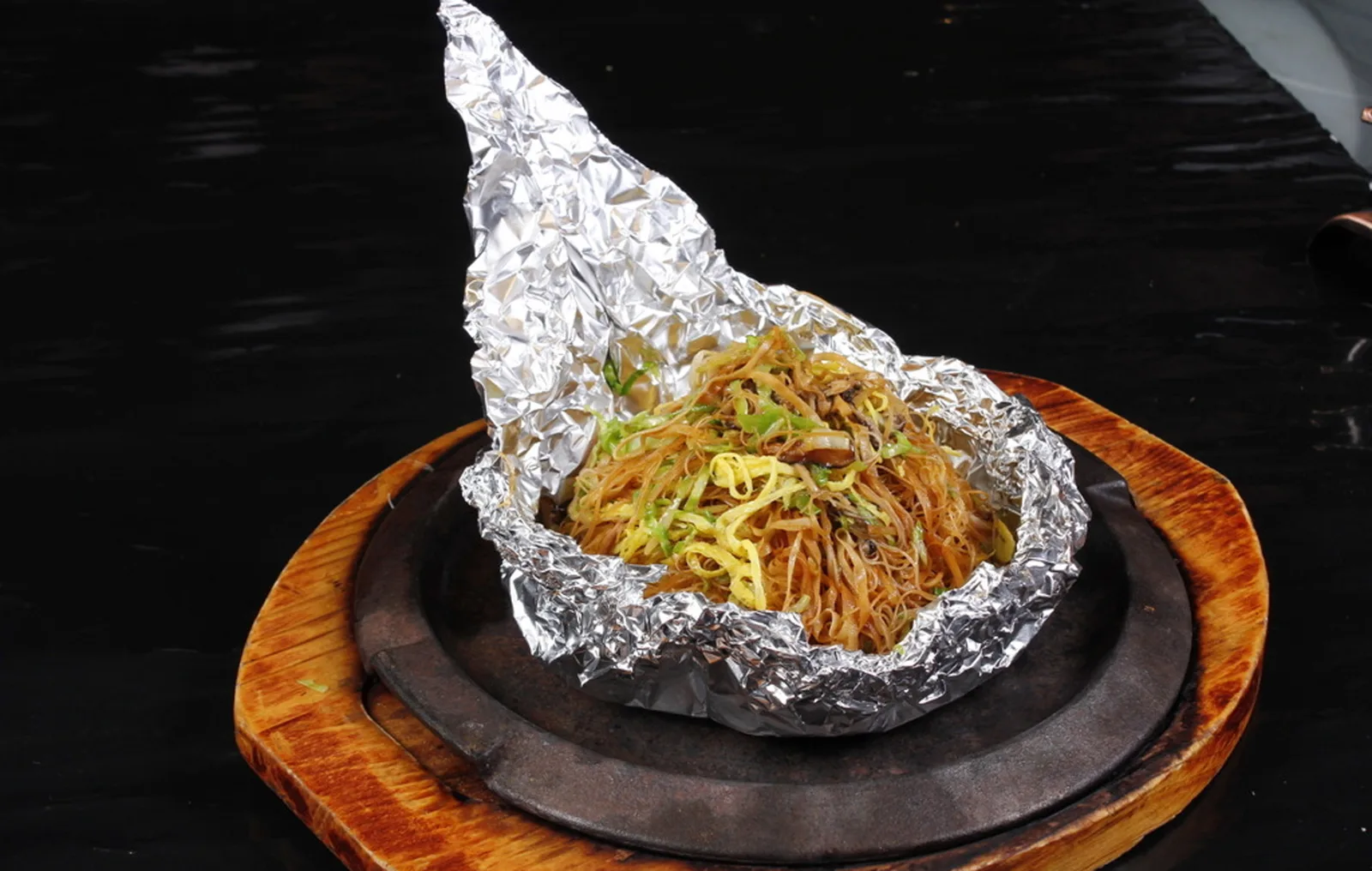 Chinese stir-fried noodles served from a hot iron plate