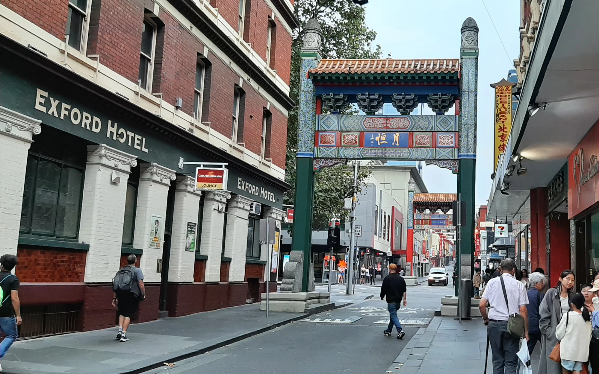 Melbourne Chinatown's archway, bakery frontage and pedestrians on Little Bourke Street