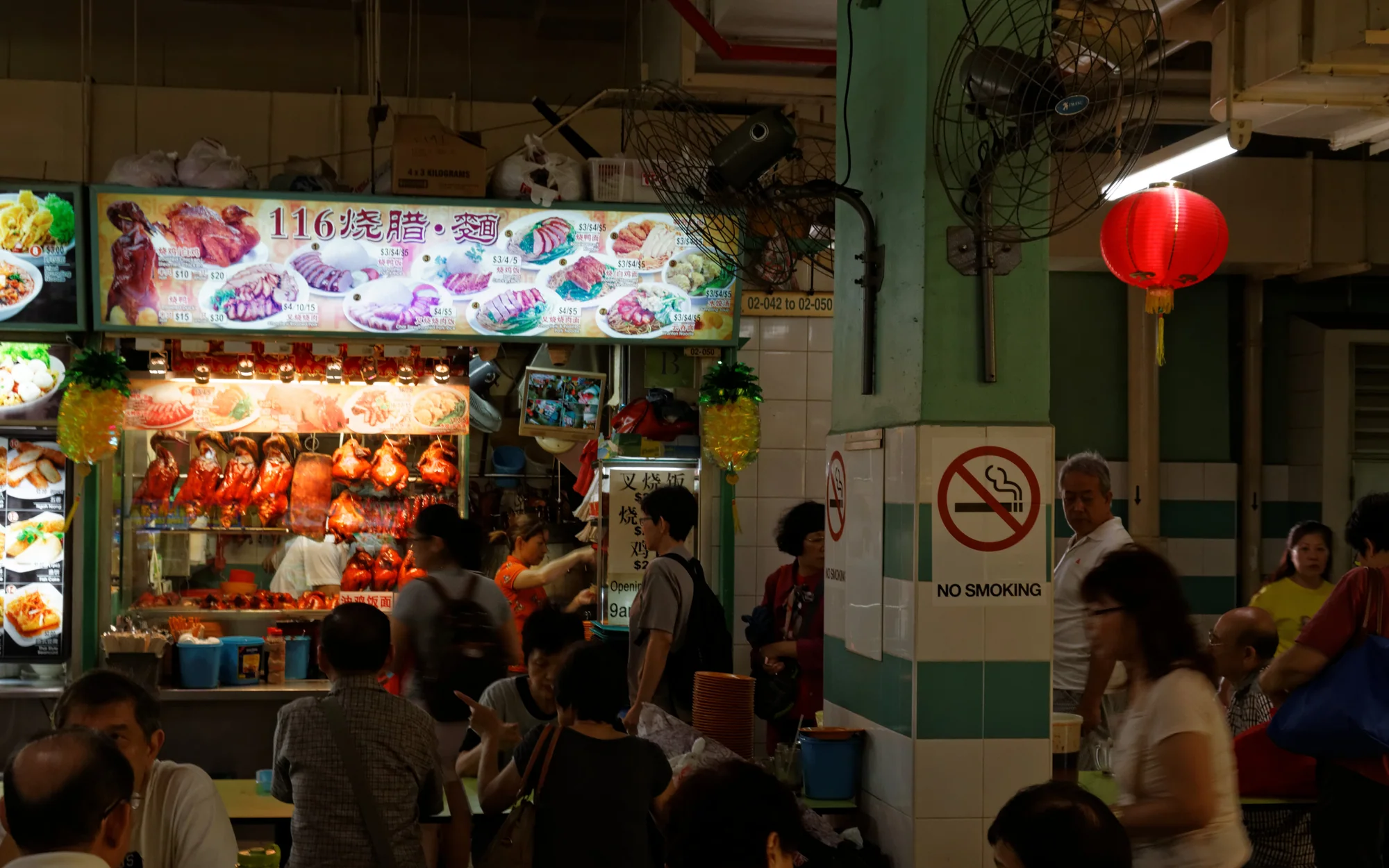 A roast-meat stall and diners inside Singapore's Chinatown Complex Food Centre