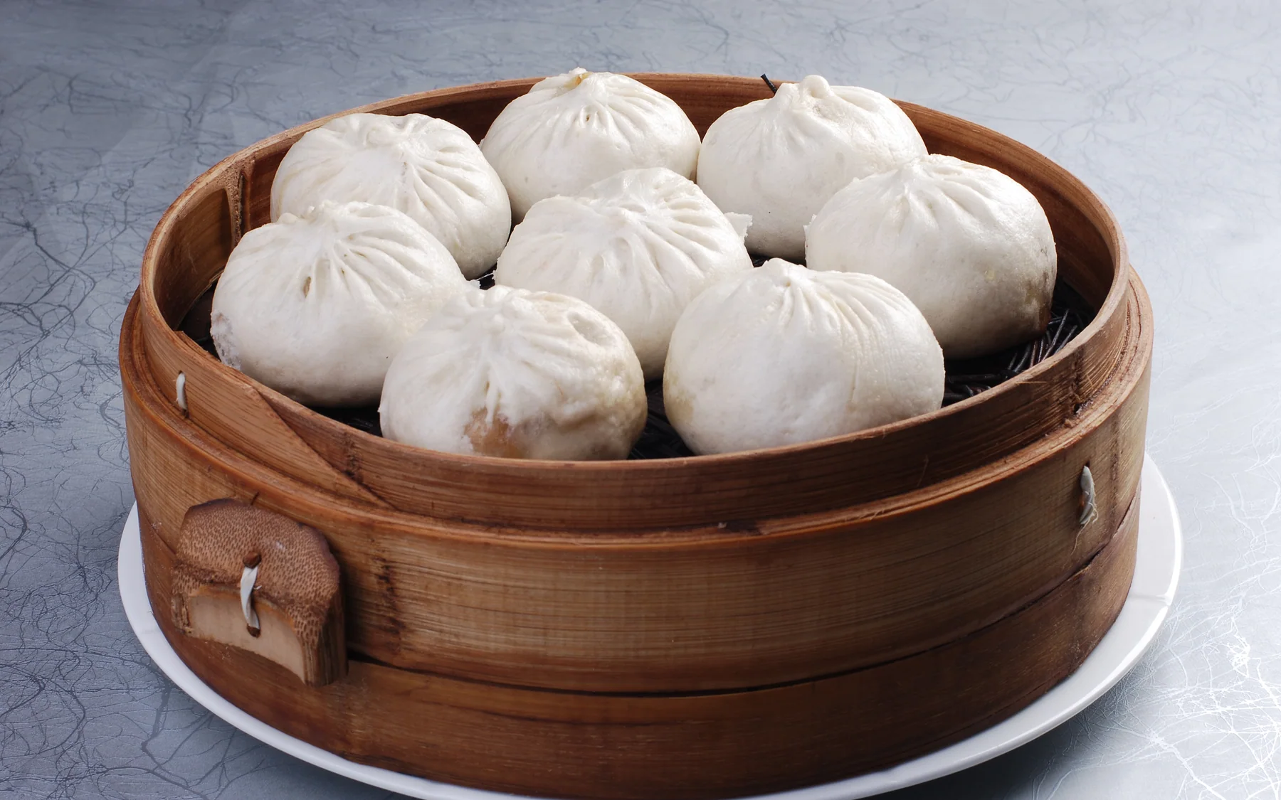 A full steamer of baozi showing how batch preparation turns slow kitchen work into quick service