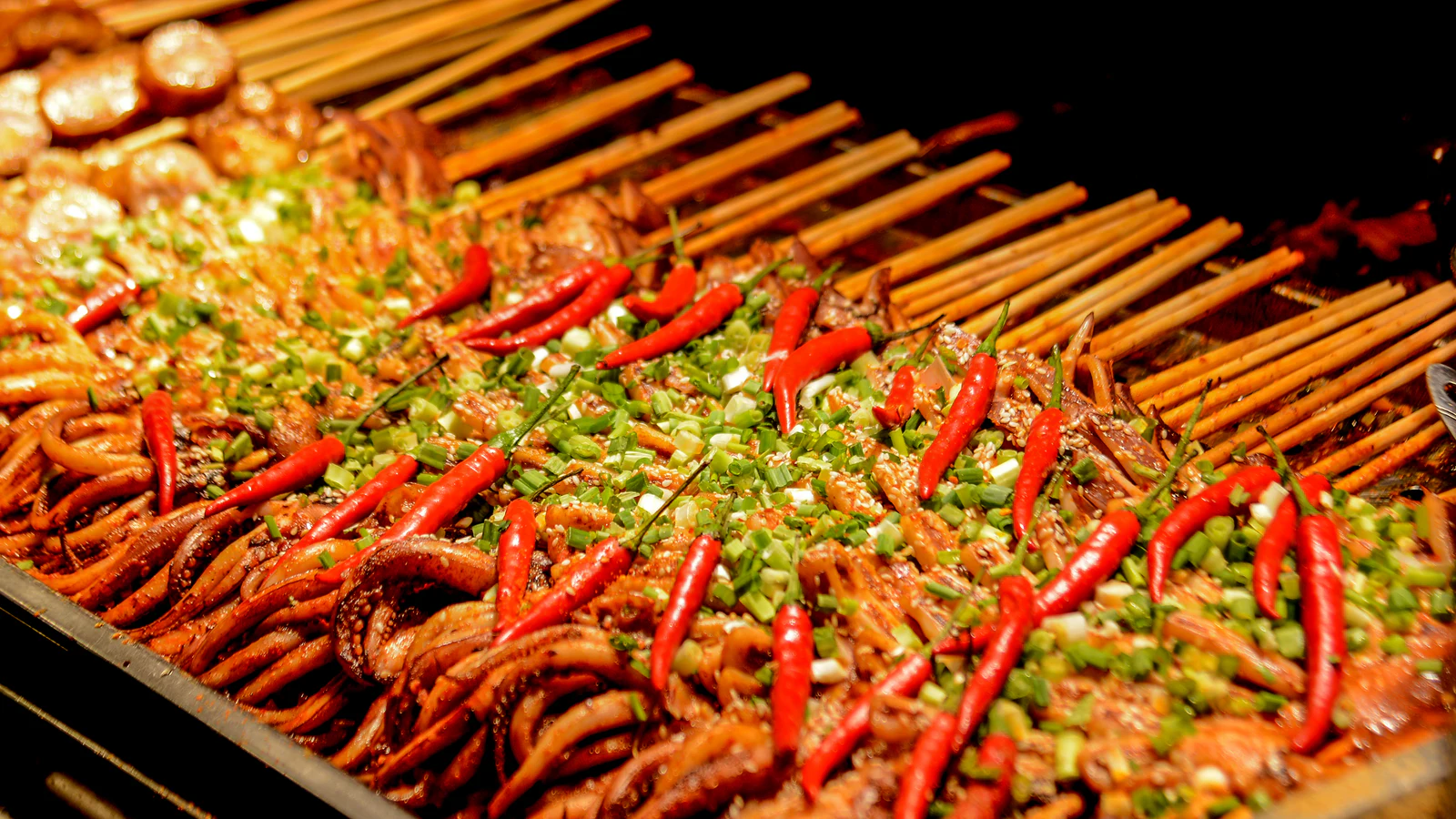 Chili-covered skewered foods arranged in rows at Chengdu's Jinli night market