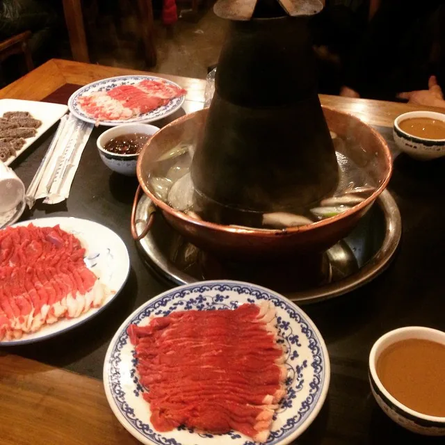 A copper pot and sliced mutton showing the clear-broth Beijing route into Chinese hot pot
