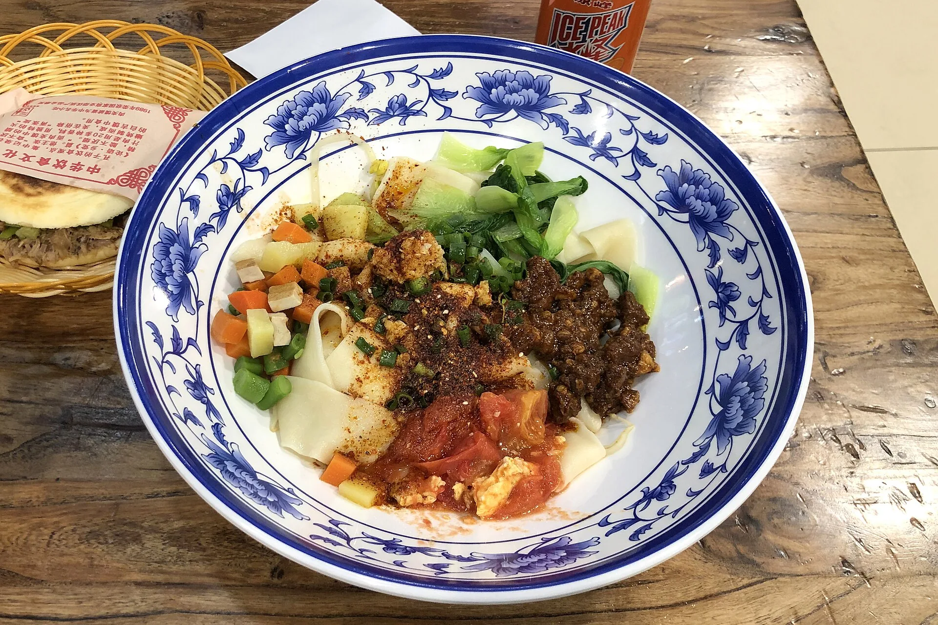 Chinese noodles served as broad biang biang noodles with vegetables, chili and meat
