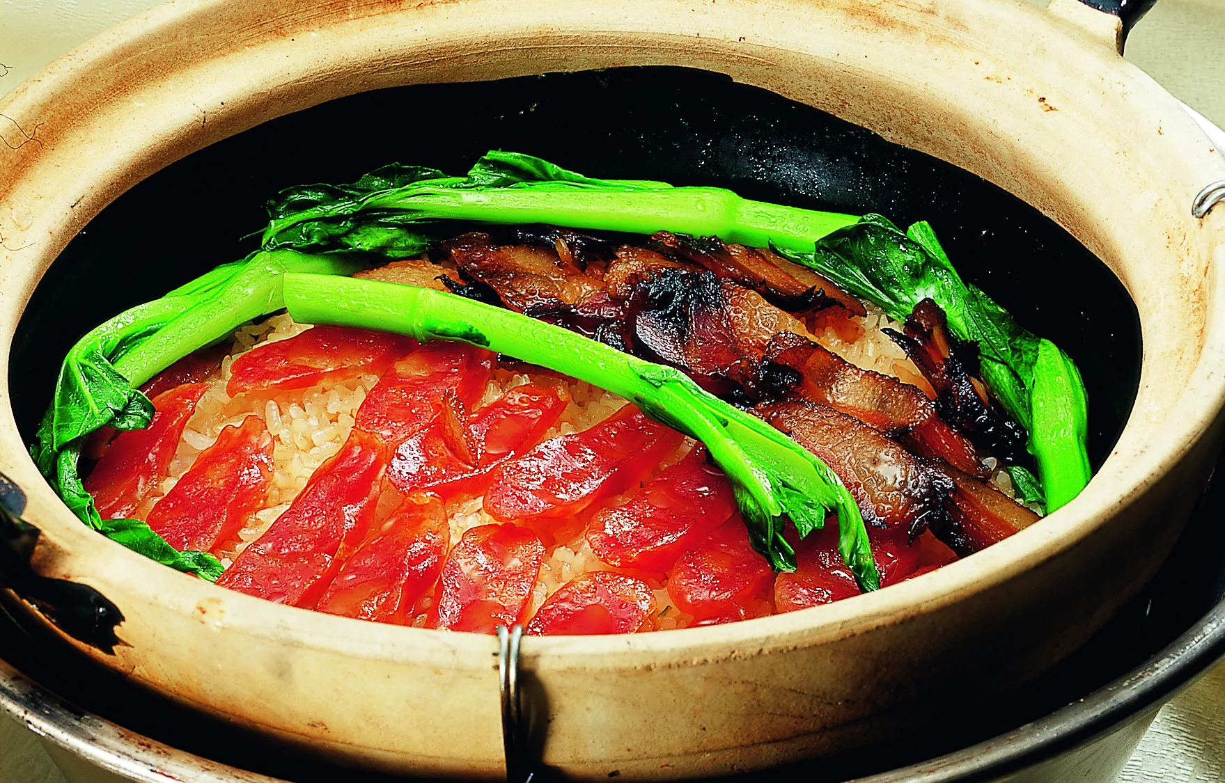 Guangzhou cured-meat clay-pot rice, whose value depends on rendered fat and the bottom crust