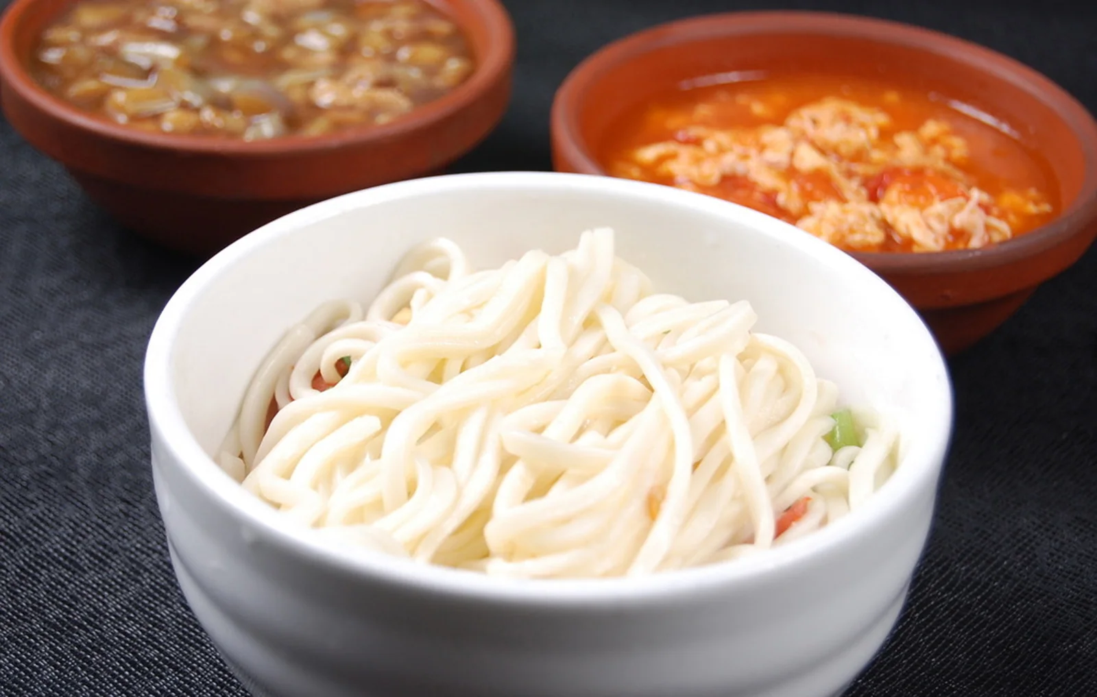 A bowl of Beijing-style noodles showing the dense wheat-based breakfast texture of the capital