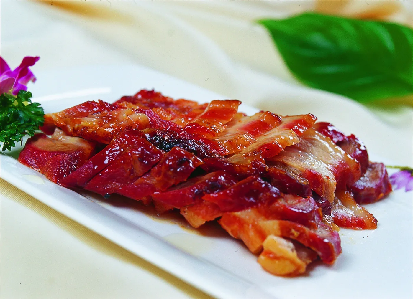 Slices of Cantonese char siu showing caramelized red edges and tender pork