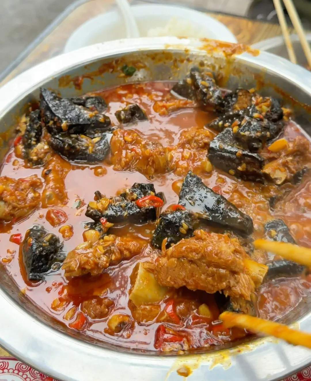 A street-side Changsha pot combining black tofu, pork ribs, chopped chili and a glossy red sauce