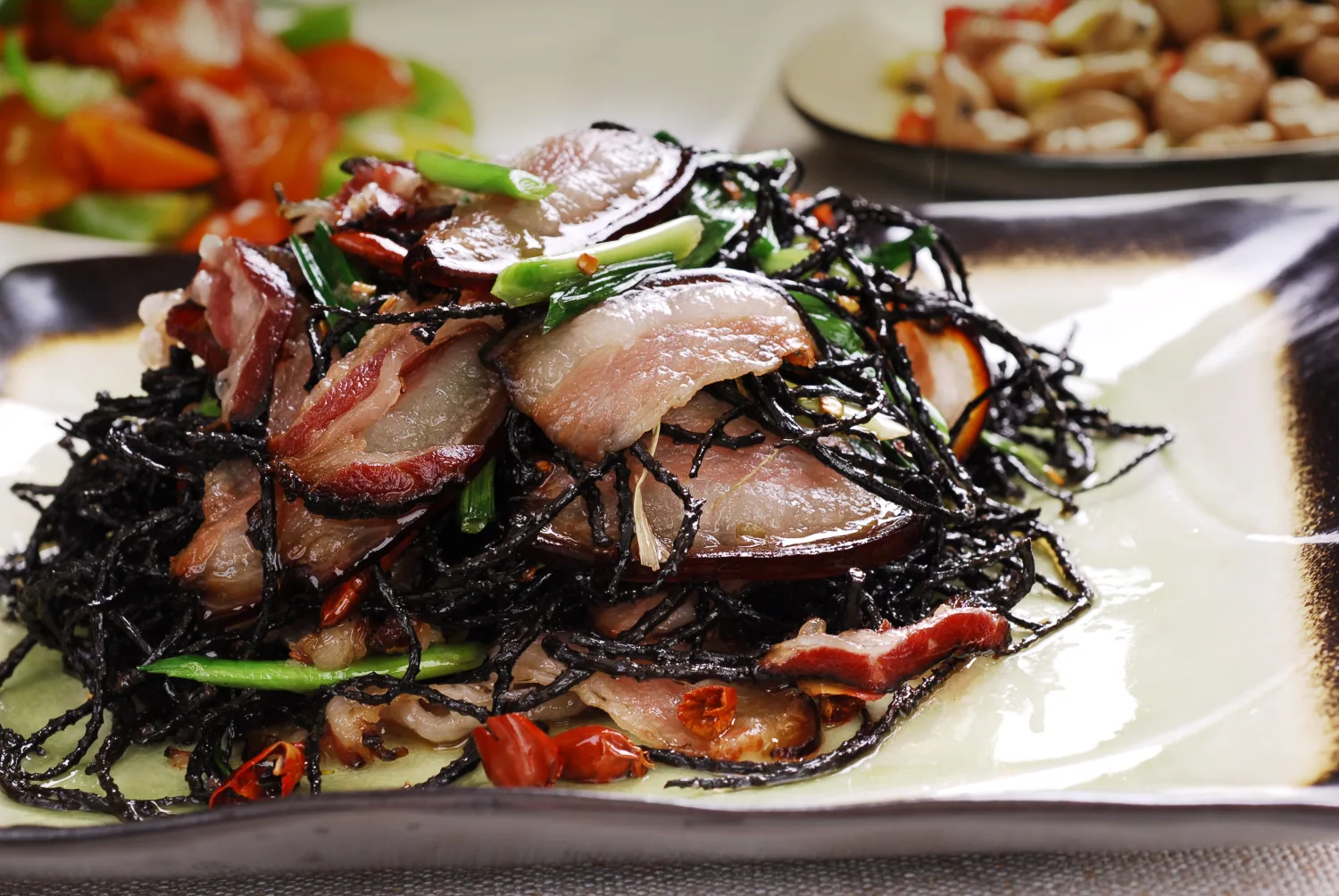 Hunan smoked pork stir-fried with a dark mountain vegetable for a Changsha shared meal