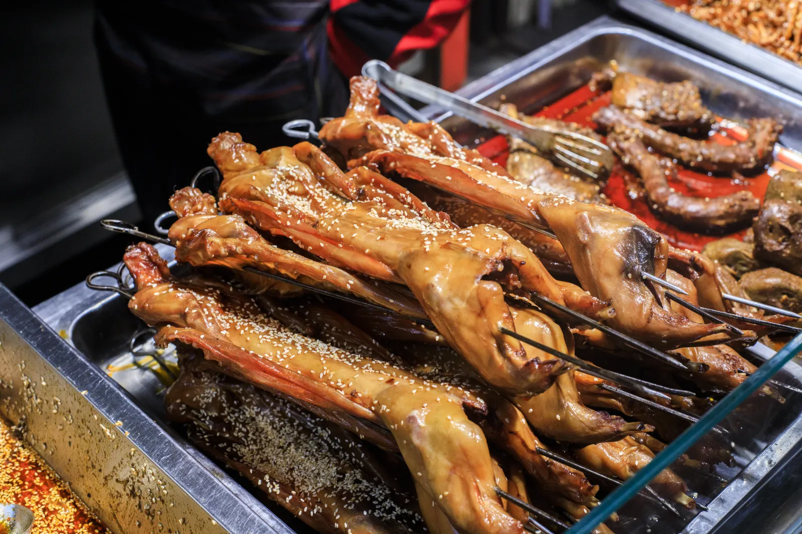 Braised street-food display with skewered poultry and other prepared ingredients