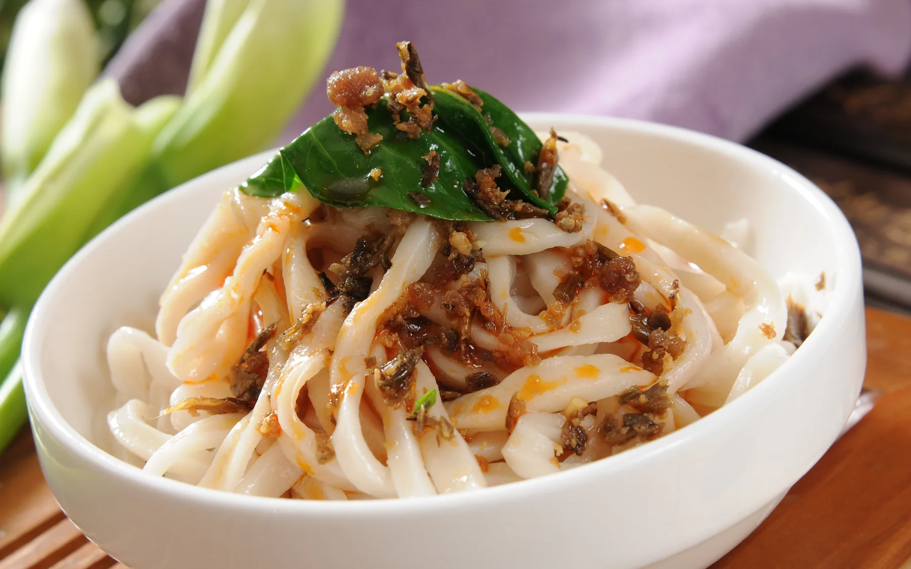 A bowl of Chengdu dan dan noodles showing the concentrated sauce and modest serving format