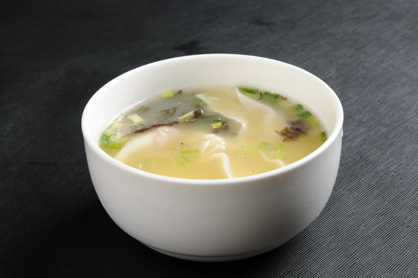 A bowl of Chongqing chaoshou dumplings in a light broth