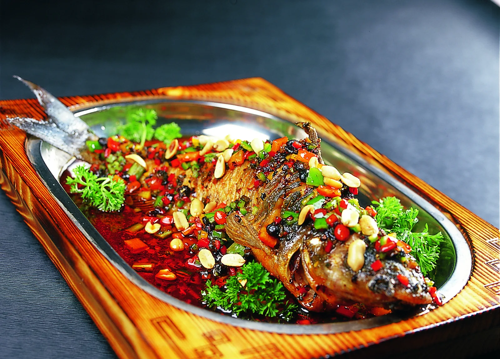 A whole Chongqing-style grilled fish in a red chile broth with aromatics