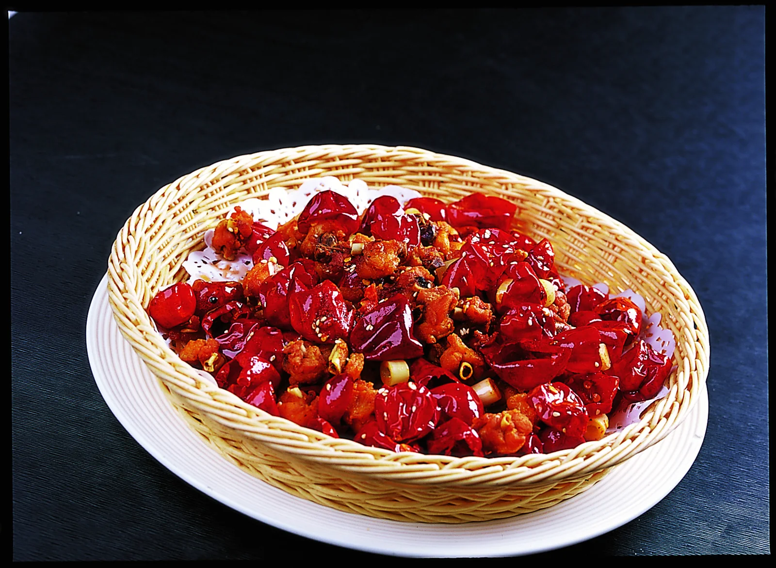 Small pieces of fried Geleshan chicken scattered through dried red chilies