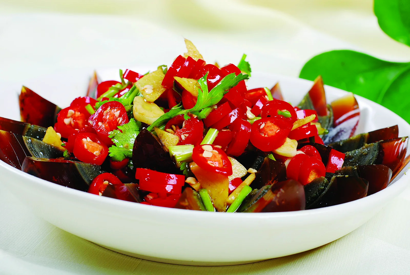 Sliced Henan preserved egg with garlic, fresh red chile and green pepper