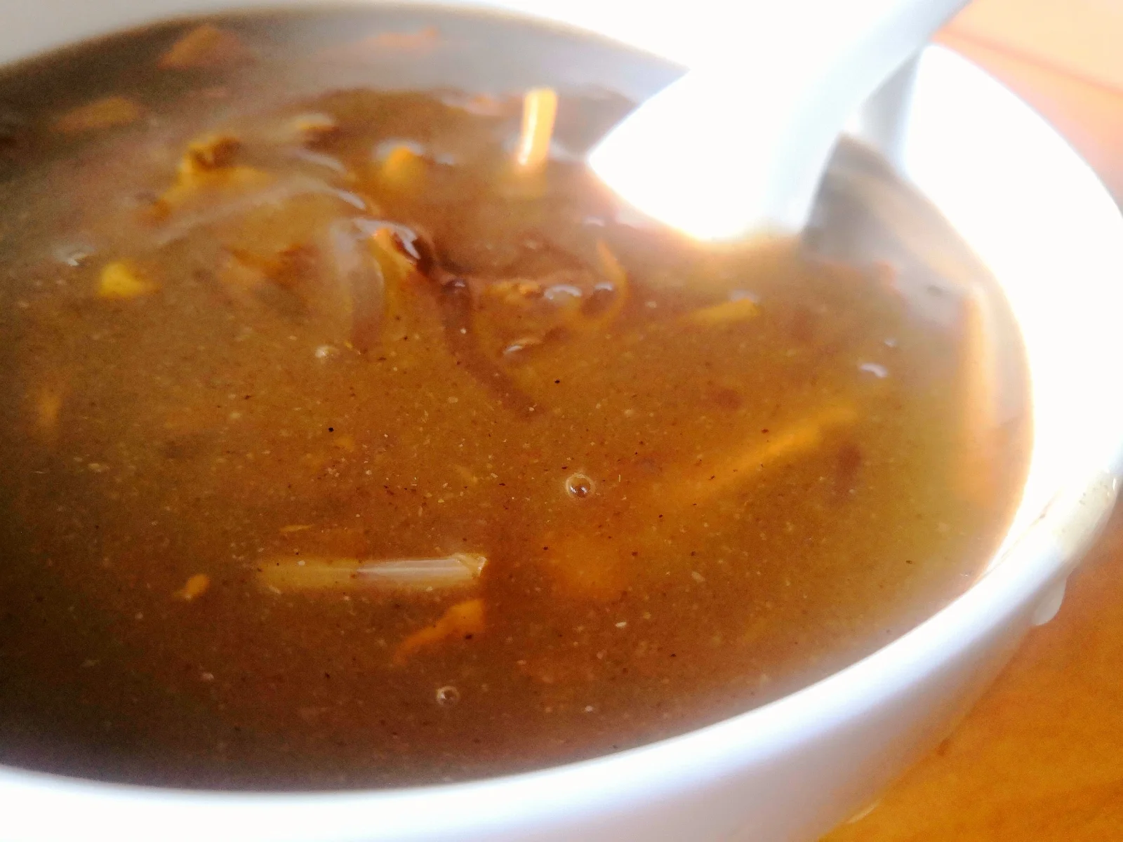 A bowl of thick brown hulatang with a white spoon