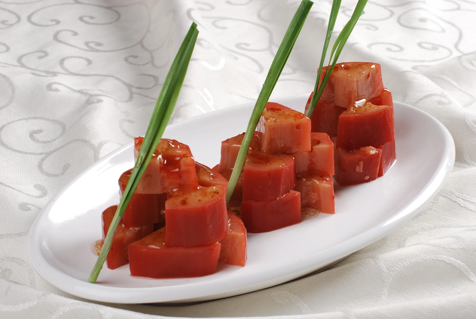 Glazed osmanthus lotus root rounds on a white plate