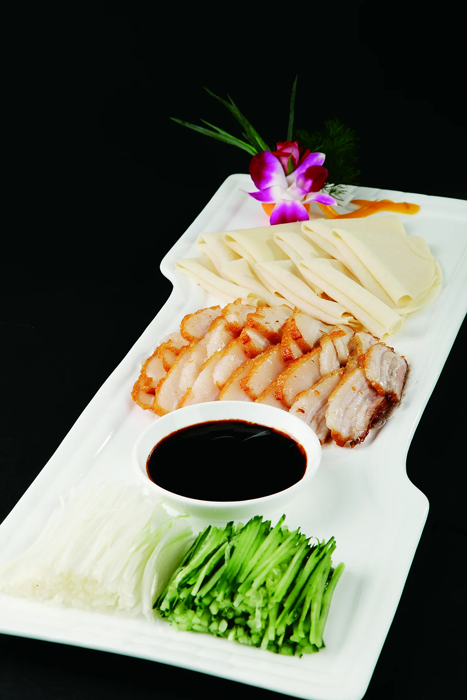 Sliced fried pork served with thin wrappers, scallion and cucumber