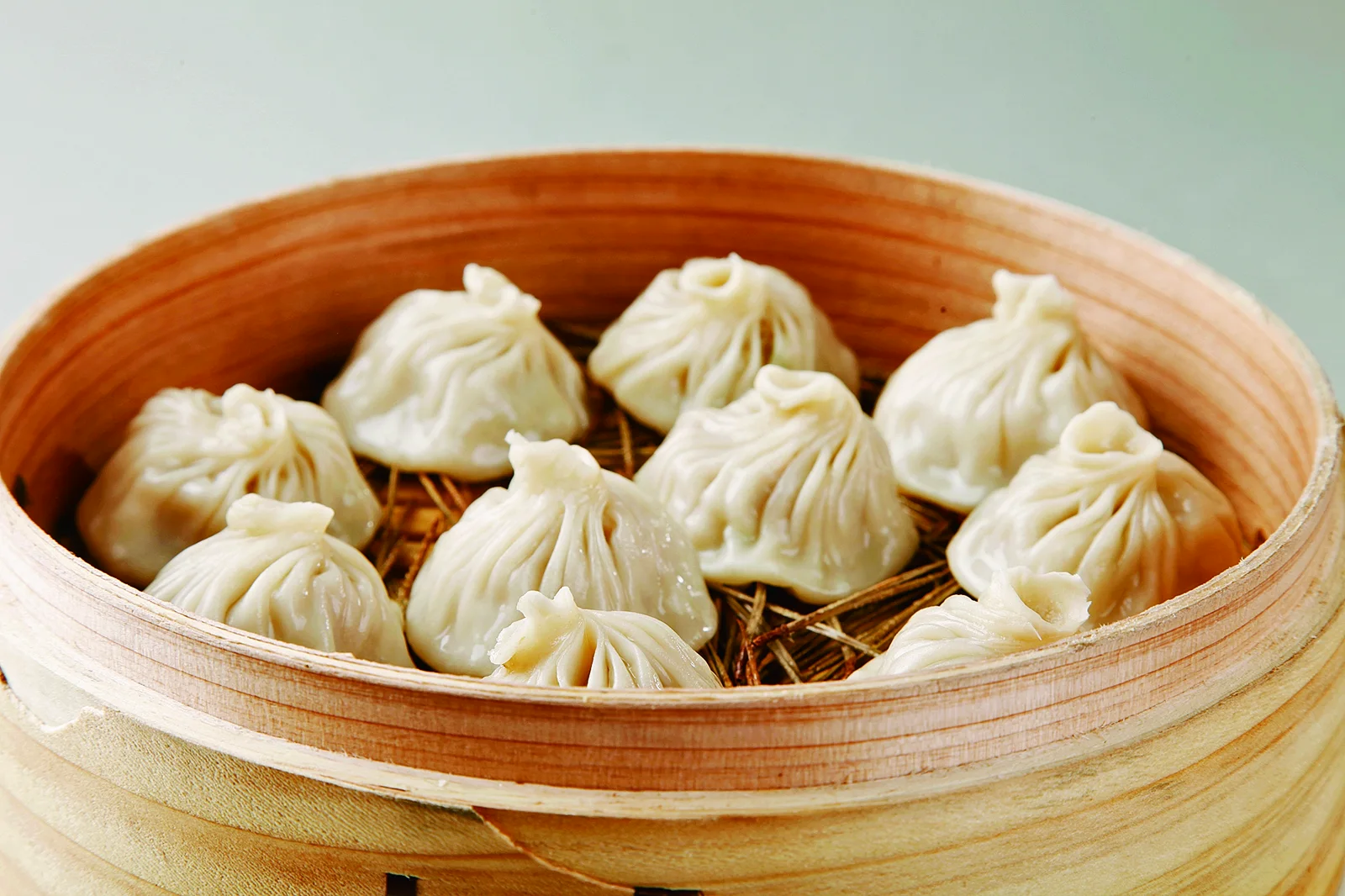 A bamboo steamer filled with pleated soup dumplings associated with Kaifeng