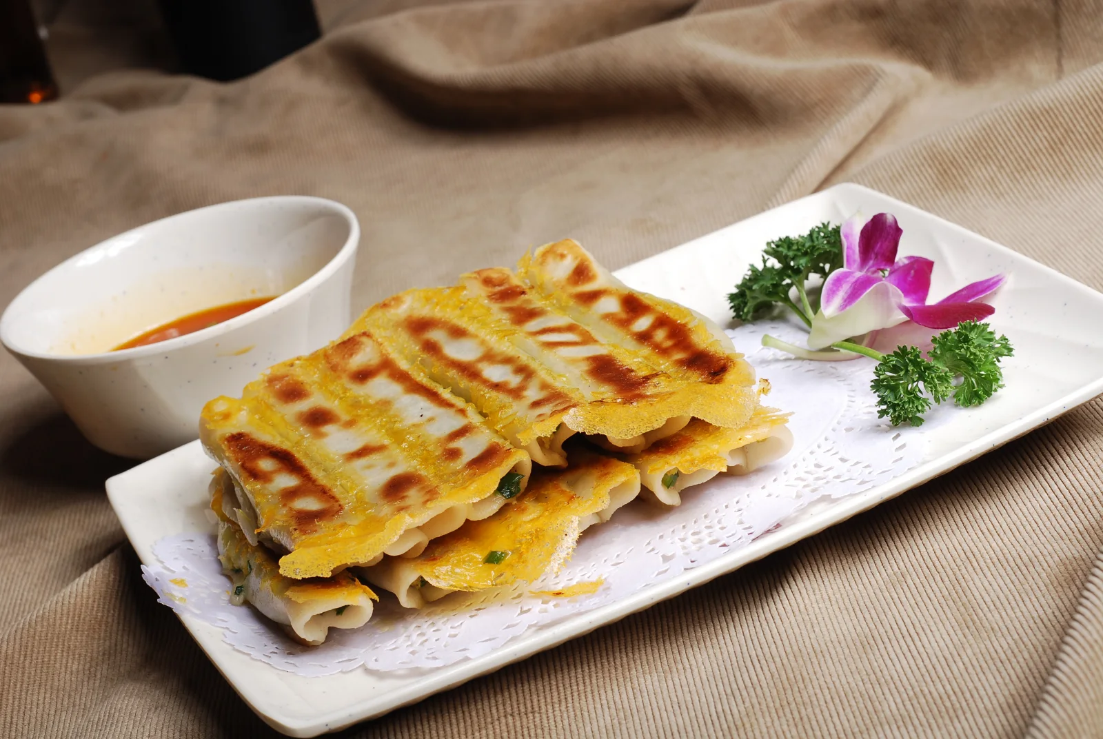Golden Luoyang-style guotie arranged beside a small dipping sauce