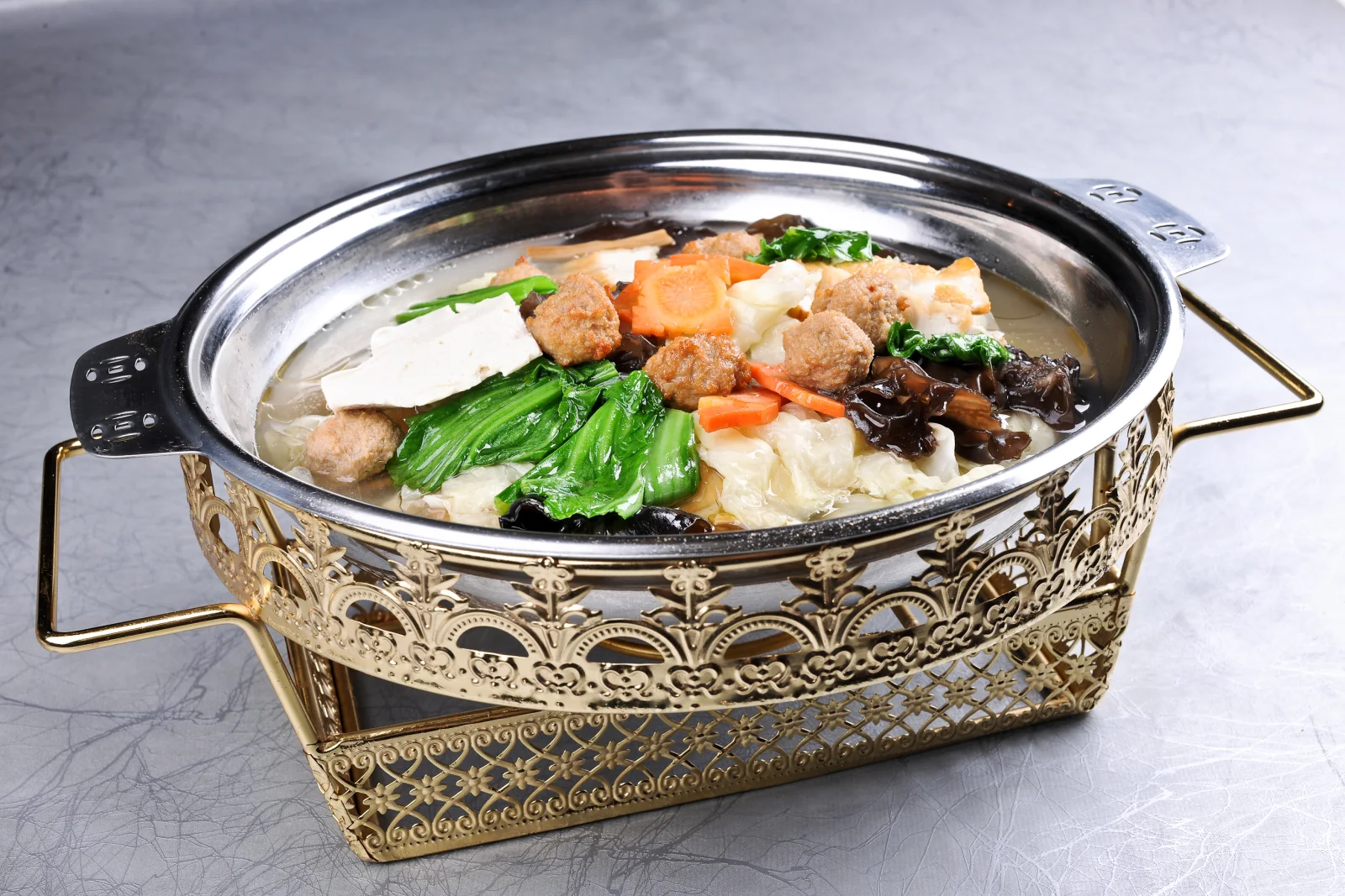 A mixed Henan stew showing fried meat, vegetables and broth in a shared metal pot