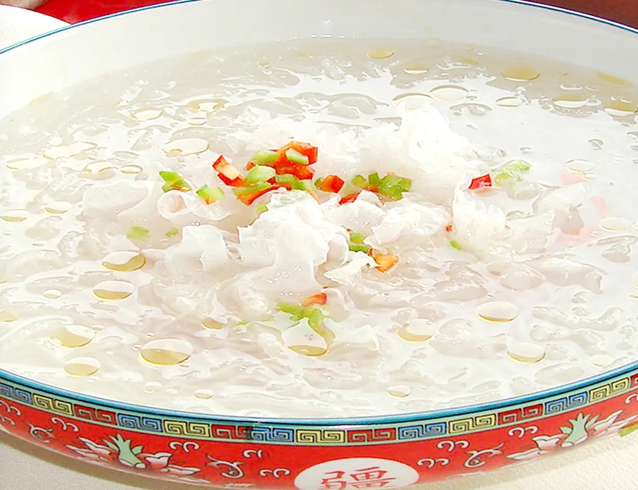 A bowl of Luoyang peony yan cai served with pale broth and garnishes