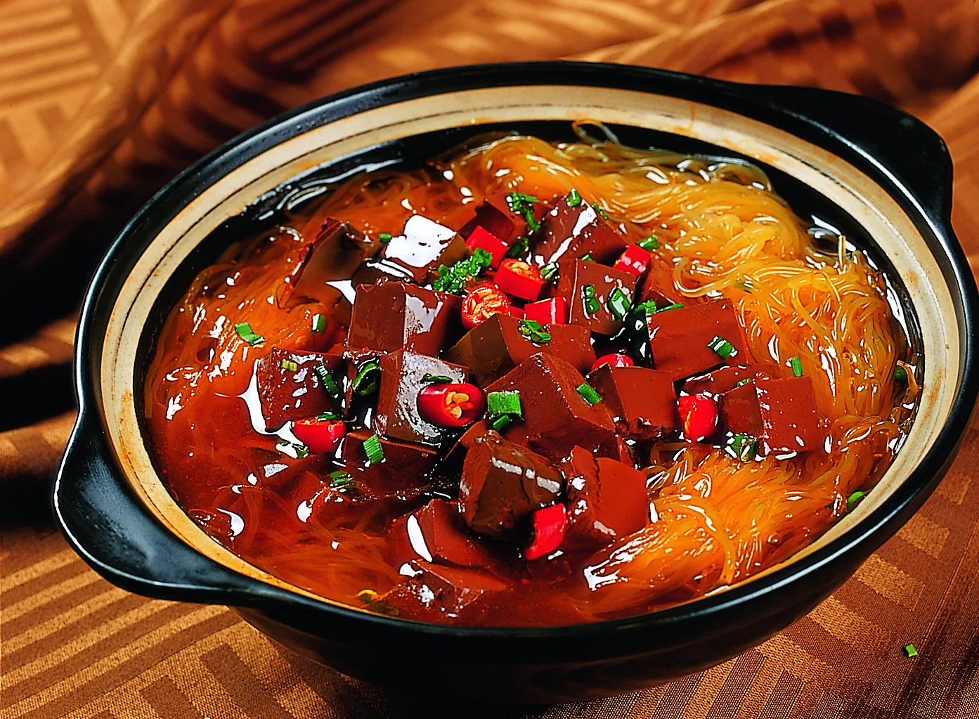 A restaurant casserole-style version of duck blood vermicelli with greens and toppings