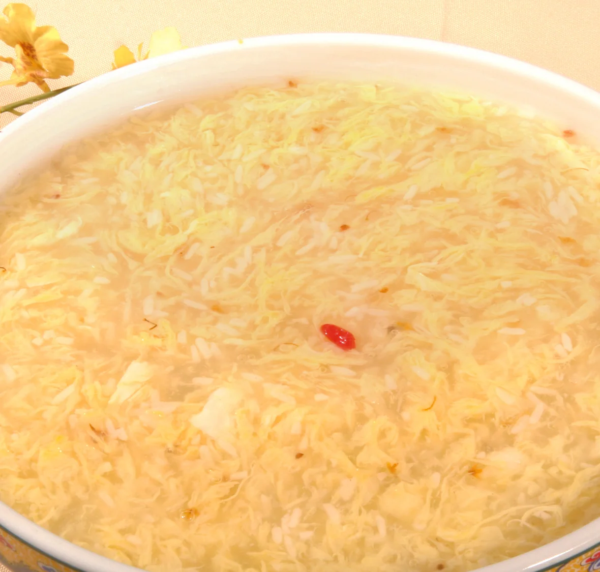 A pale fermented-rice sweet soup with fine egg ribbons, osmanthus and a few red goji berries