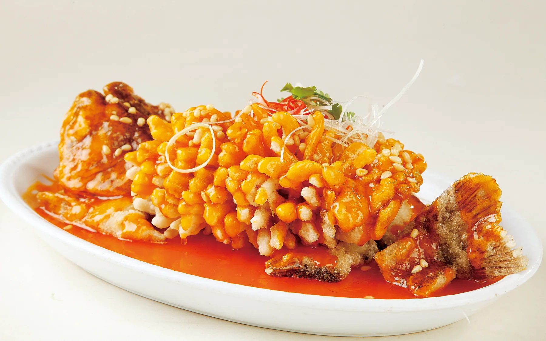 Suzhou squirrel mandarin fish showing scored knife work, crisp sections and bright sweet-sour sauce
