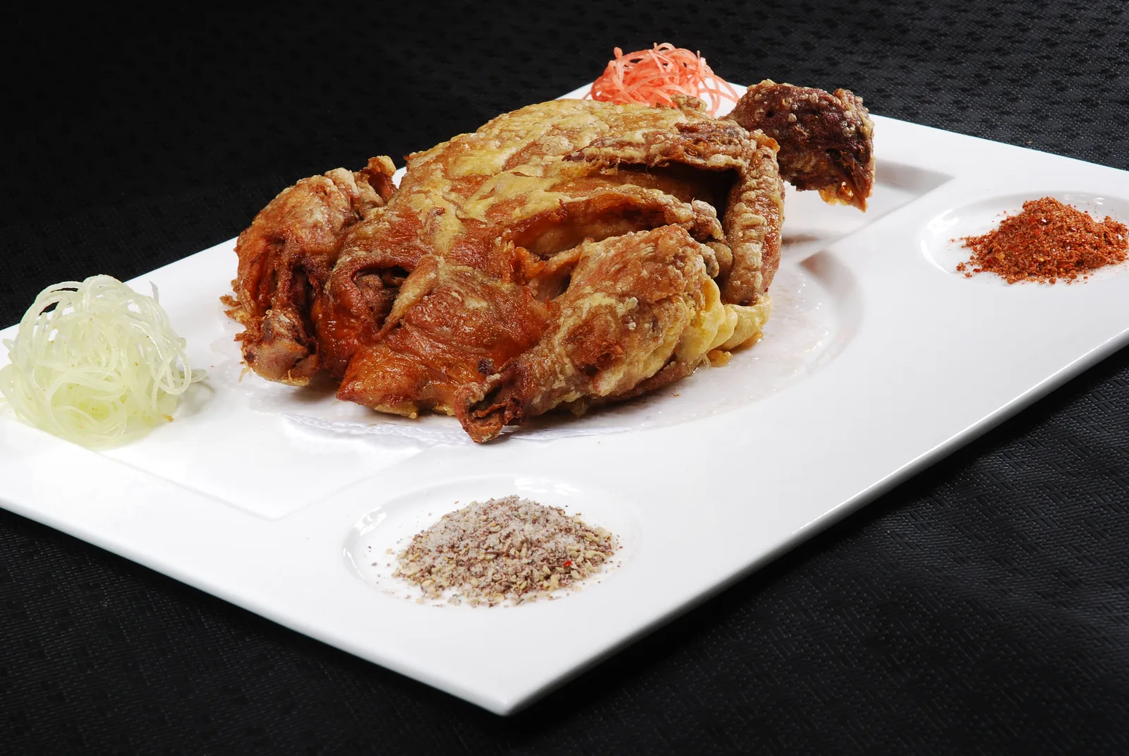 Whole gourd chicken served with dry spices on a long platter