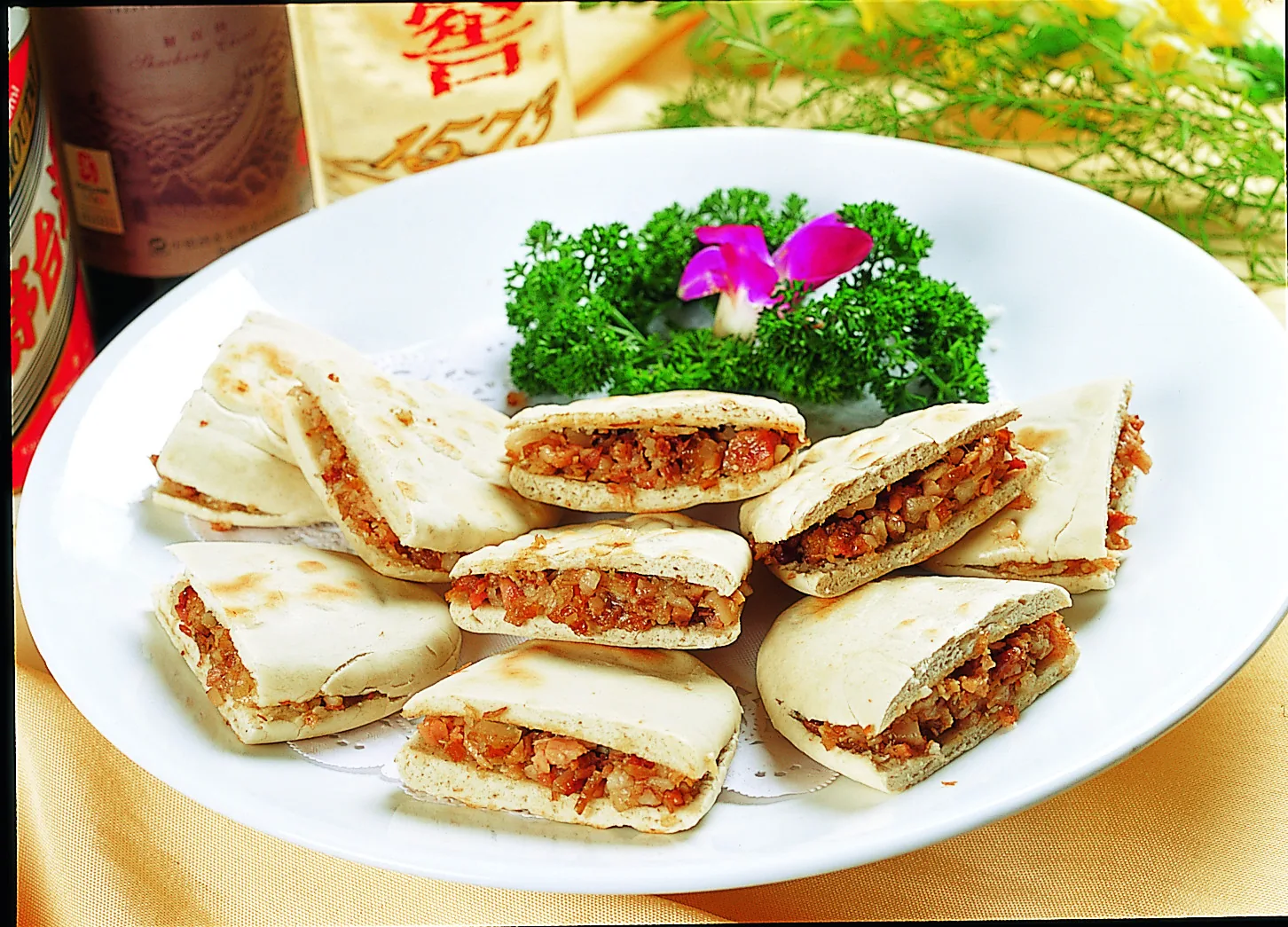 Pieces of Xi'an-style lazhi roujiamo showing braised pork inside baked wheat bread