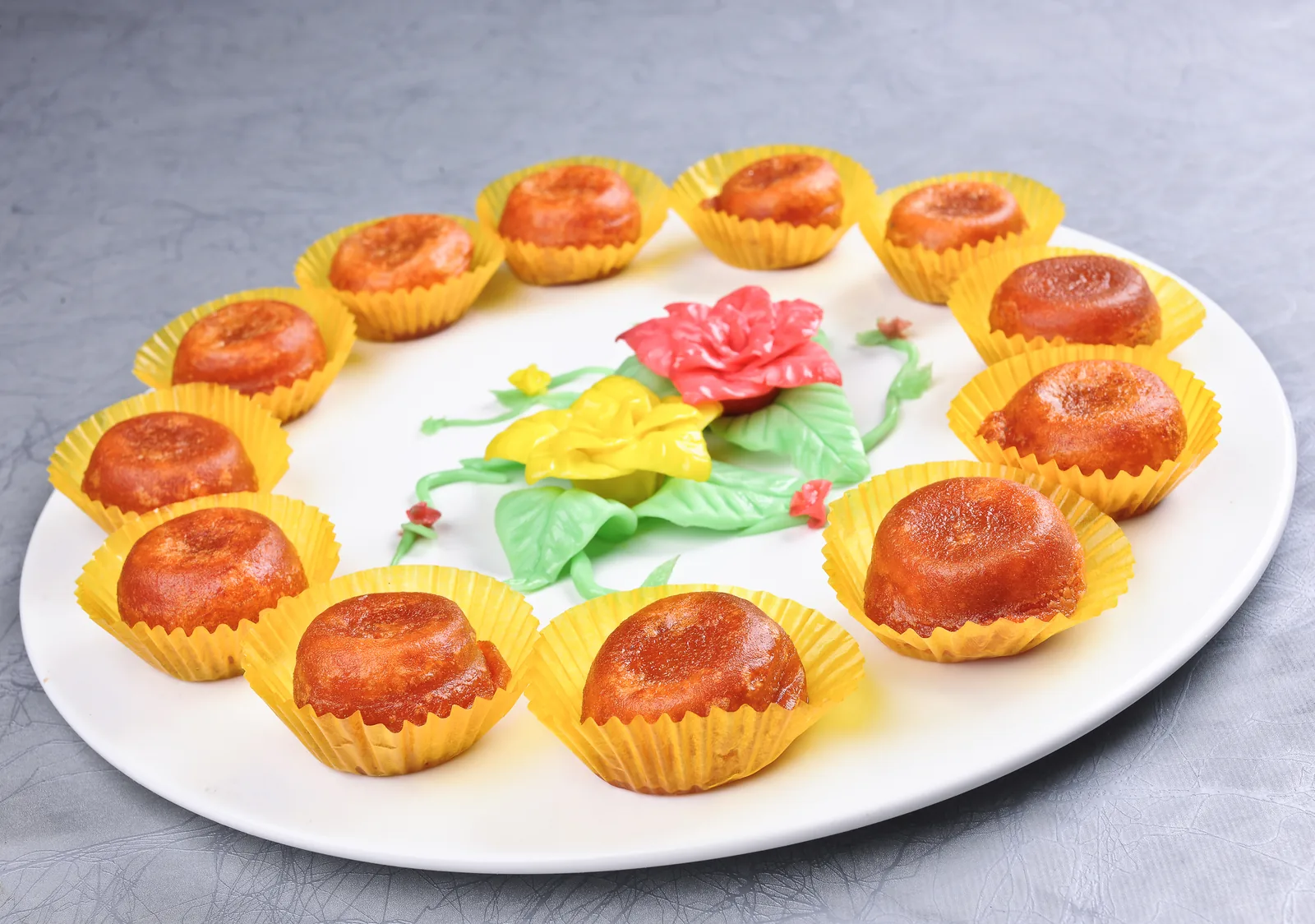 Golden persimmon cakes arranged around a carved fruit garnish