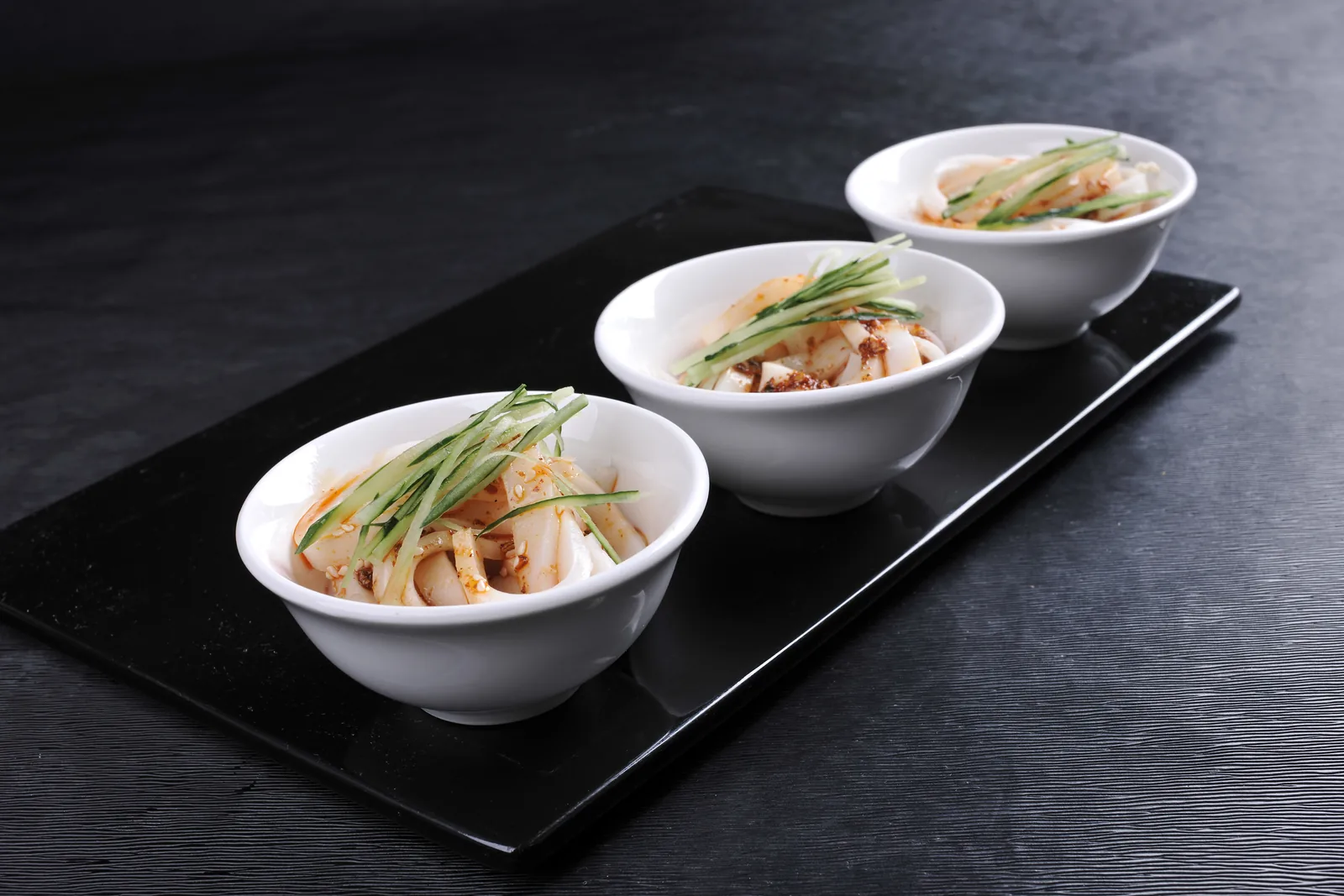 Small bowls of Qinzhen-style rice noodles with cucumber and chile oil