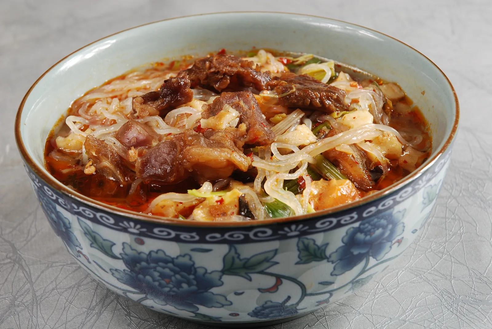 A bowl of stir-fried paomo with beef, torn bread, vegetables and red seasoning