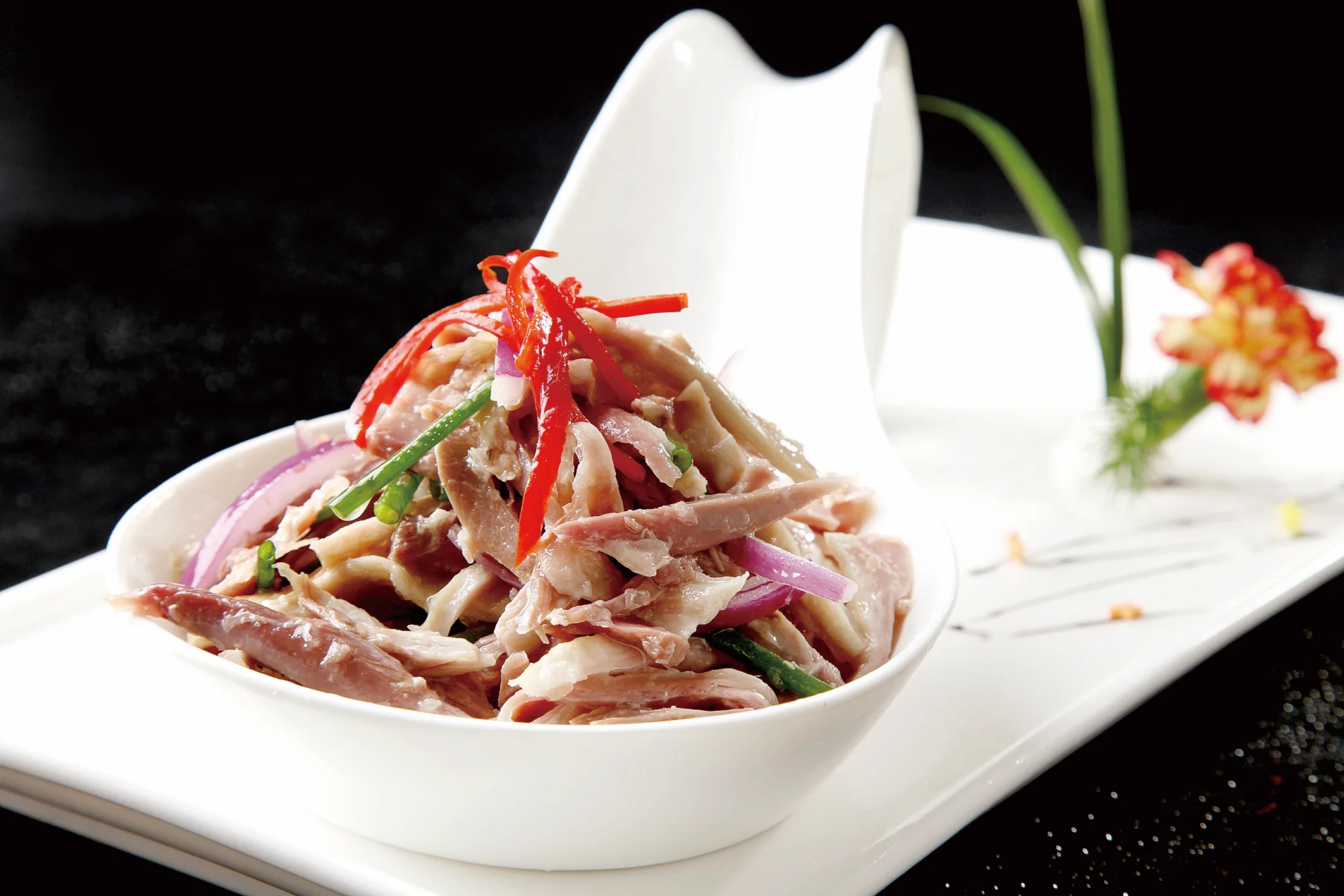 Sliced Yangzhou cured goose arranged as a cold platter with vegetables
