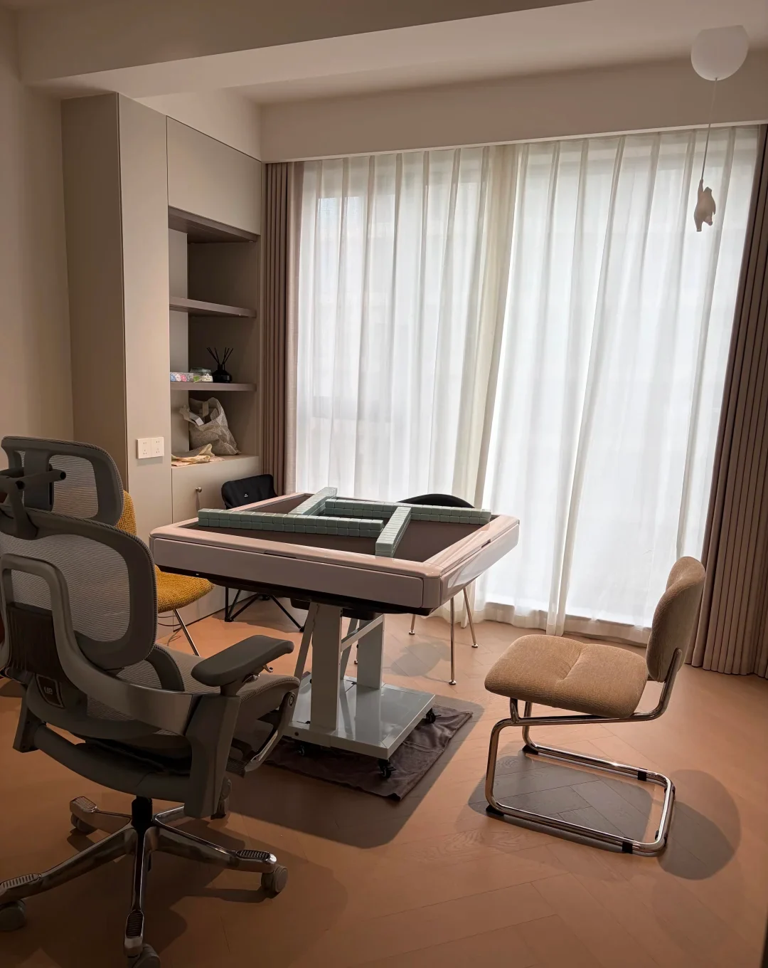 A dedicated automatic mahjong table surrounded by four different chairs in a modern home