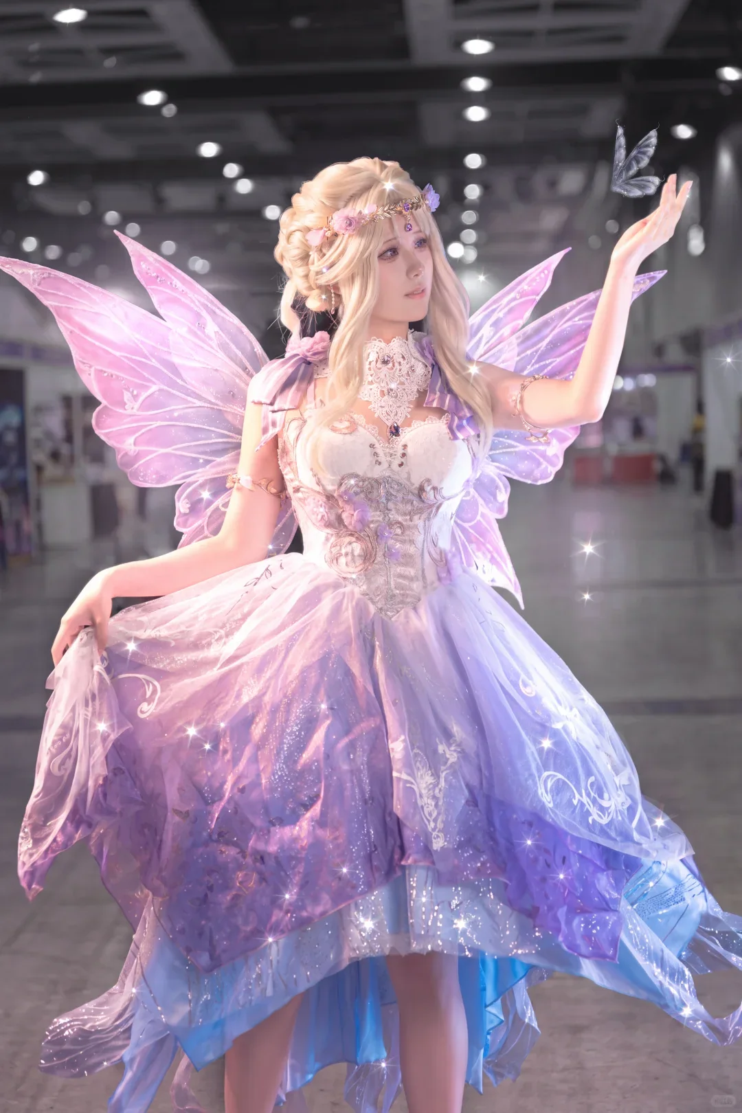 Cosplayer in a pale green fairy-inspired dress posing in a garden with digitally added wings and light effects