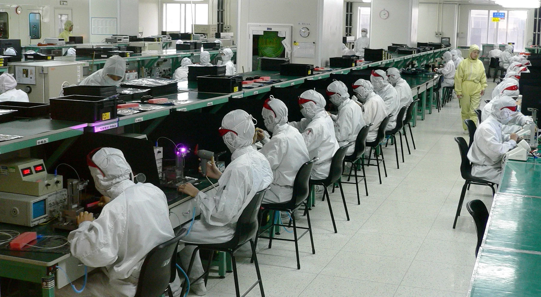 Workers at repeated assembly stations in a Shenzhen electronics factory in 2005
