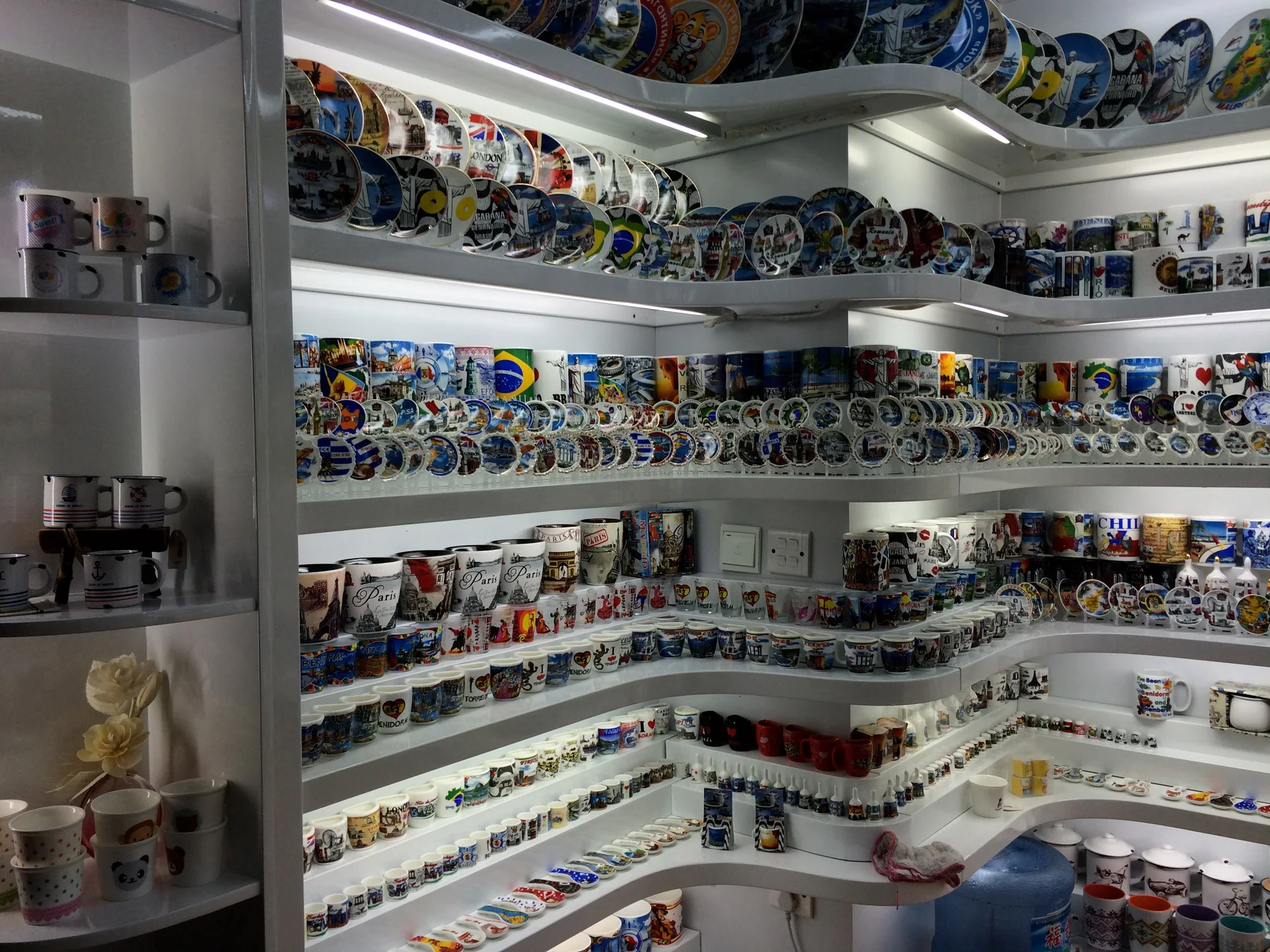 Souvenir mugs and decorative plates displayed on shelves at Yiwu International Trade Mart