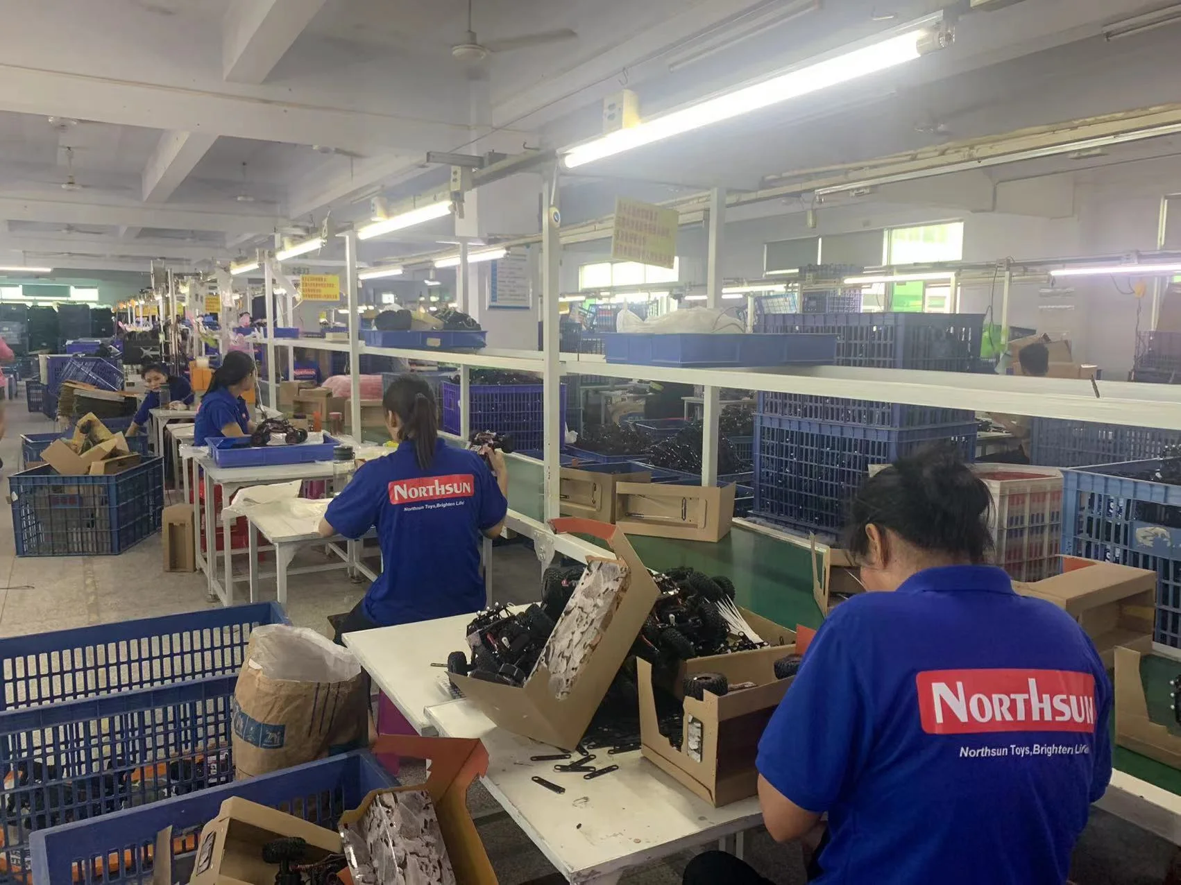 Workers assembling toys at repeated workstations on a Chinese production line