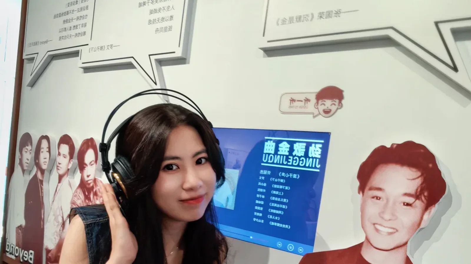 Visitor wearing headphones at a Cantonese listening station in a Lingnan dialect museum