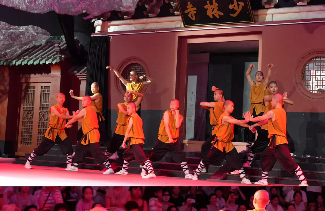 A public Shaolin-themed performance combining synchronized group forms, flexibility and a staged conditioning feat